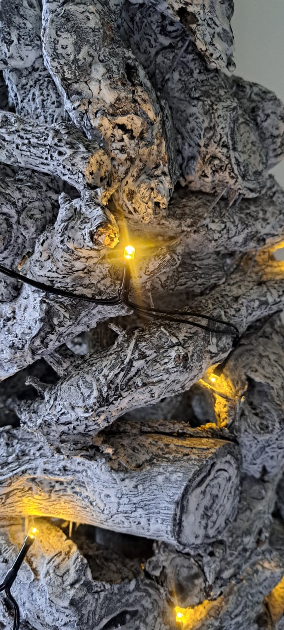 Sfeervolle houten kerstboom van massieve stammetjes.
