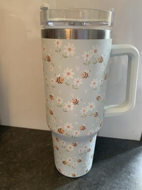 Tumbler beker heeft een vrolijke print van bijen en bloemen.