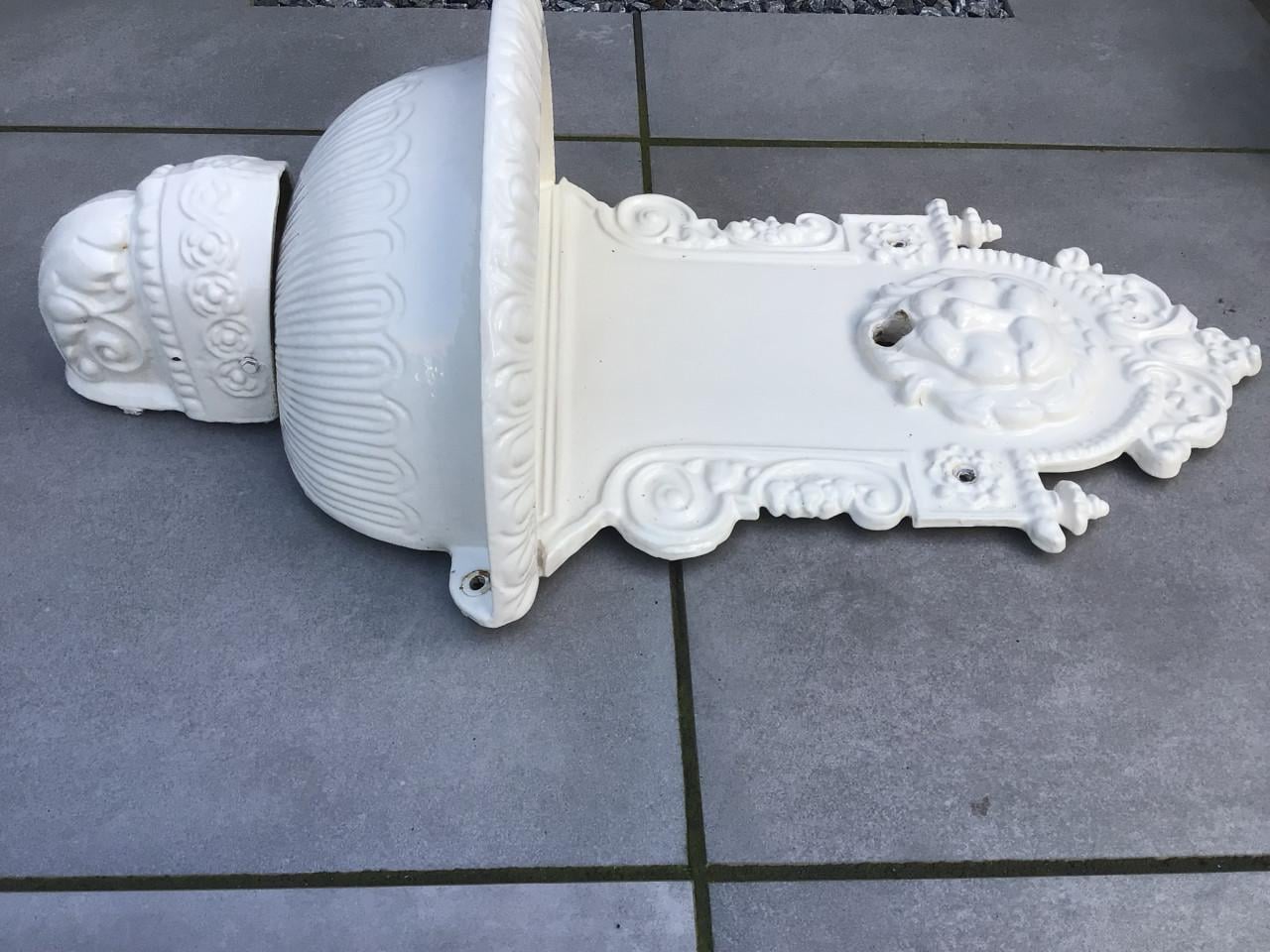 Gietijzeren wandlantaarn en fontein