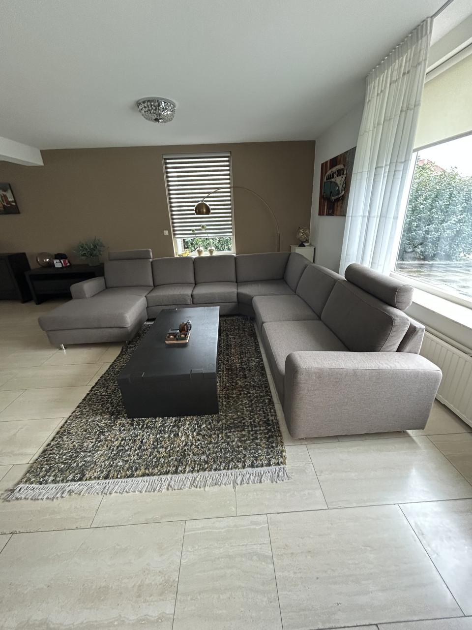 Mooie hoekbank met loungegedeelte en hoofdsteunen in Taupe kleur.