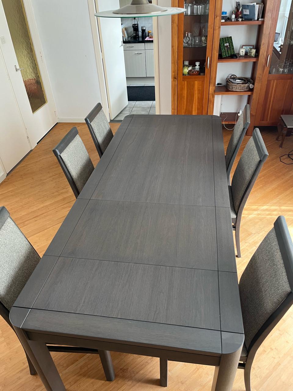 Eettafel met verstelbaar blad en zes stoelen.