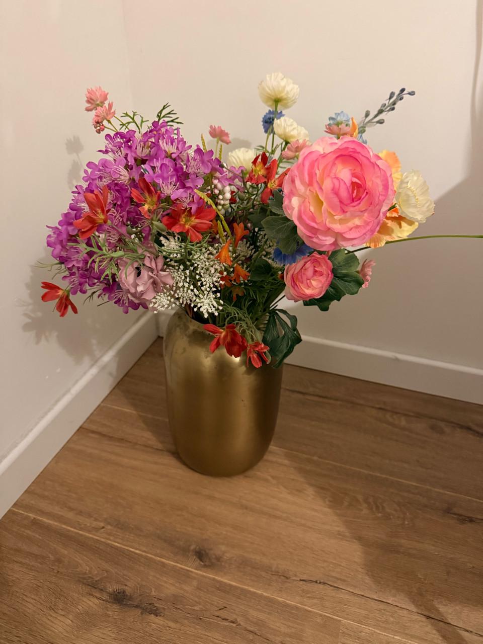 Gouden vaas met kleurrijke kunstbloemen