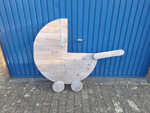 Leuke steigerhouten kinderwagen om in de tuin te zetten bij geboorte