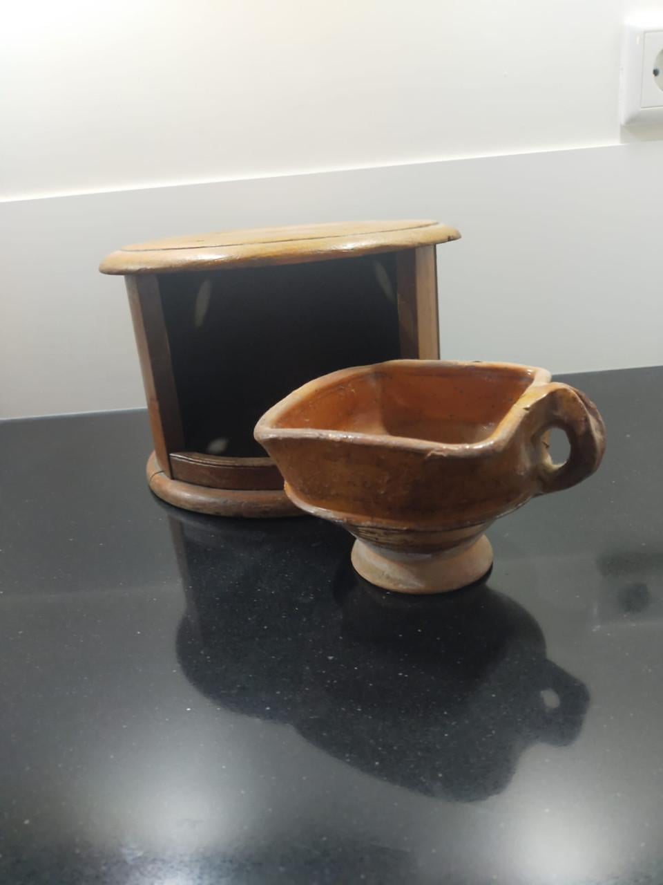 Antieke ronde voetenstoof met aardewerk schaaltje