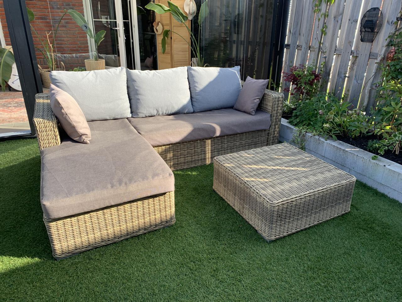 Rieten loungeset, met kussens en tafel.