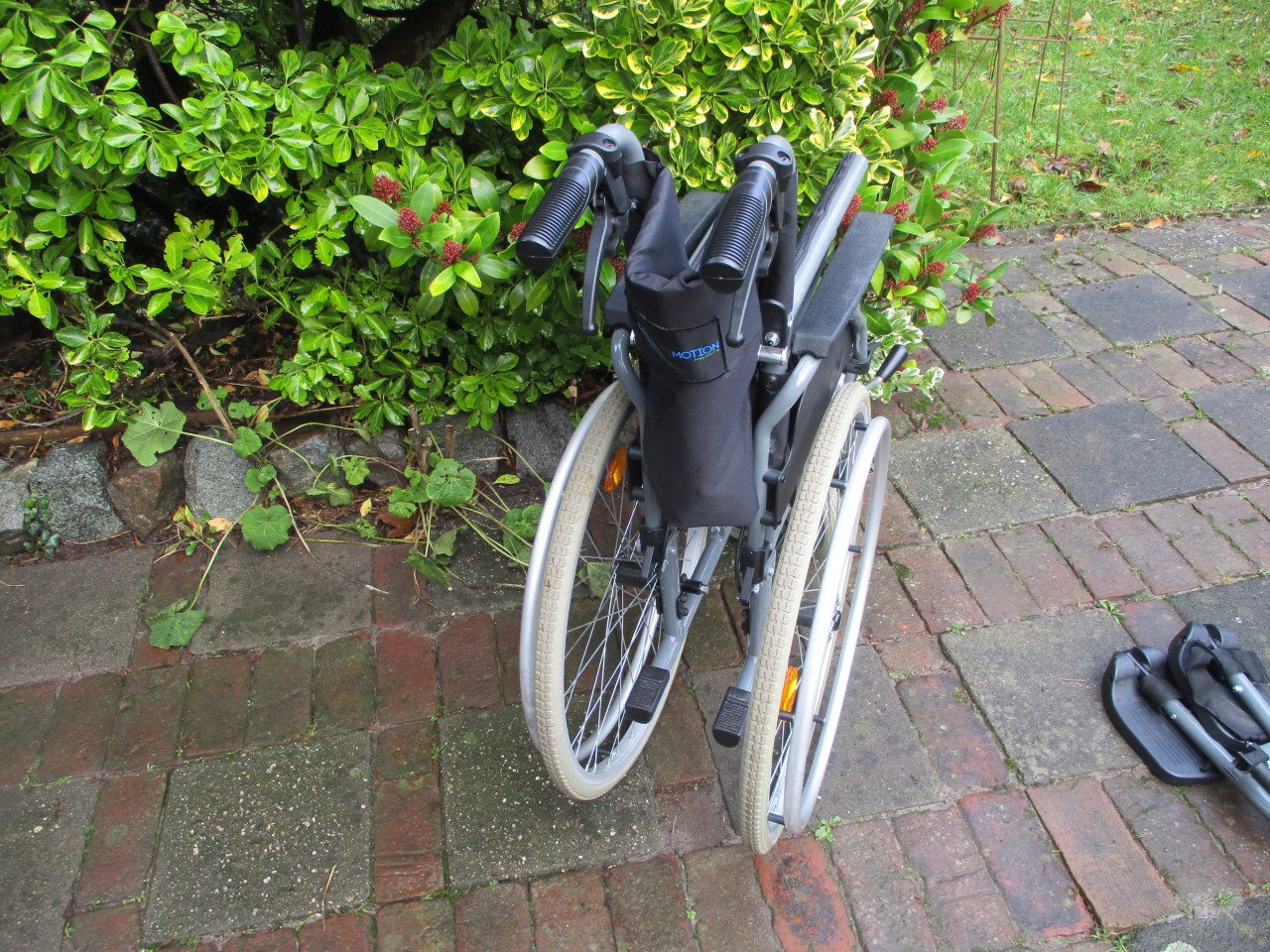 Zeer handige rolstoel met handremmen en neerklapbare duwhandgrepen