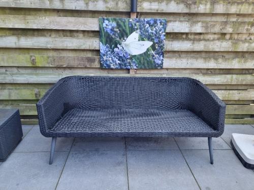 Zwart Wicker tuinbank met kussens  z.g.a.n.