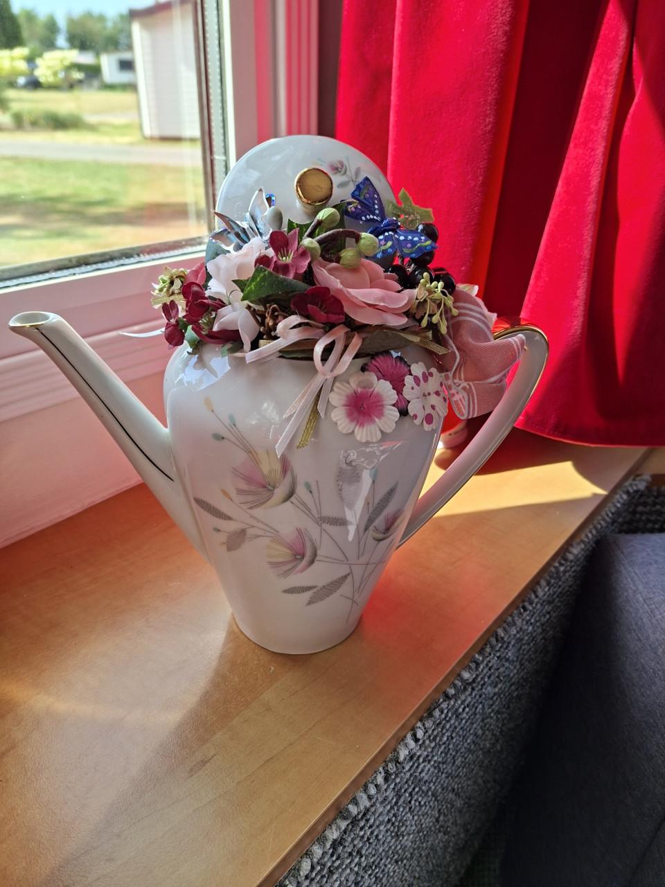 Bloemstukje/koffiepot van satijnen bloemen..