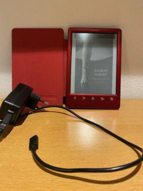 E reader merk sony met oplader buitenkaft is wat beschadigt verder goed