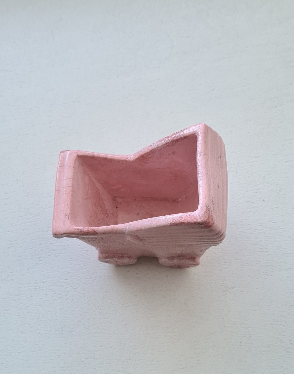 Schattig klein roze bloempotje in de vorm van een kinderwagen