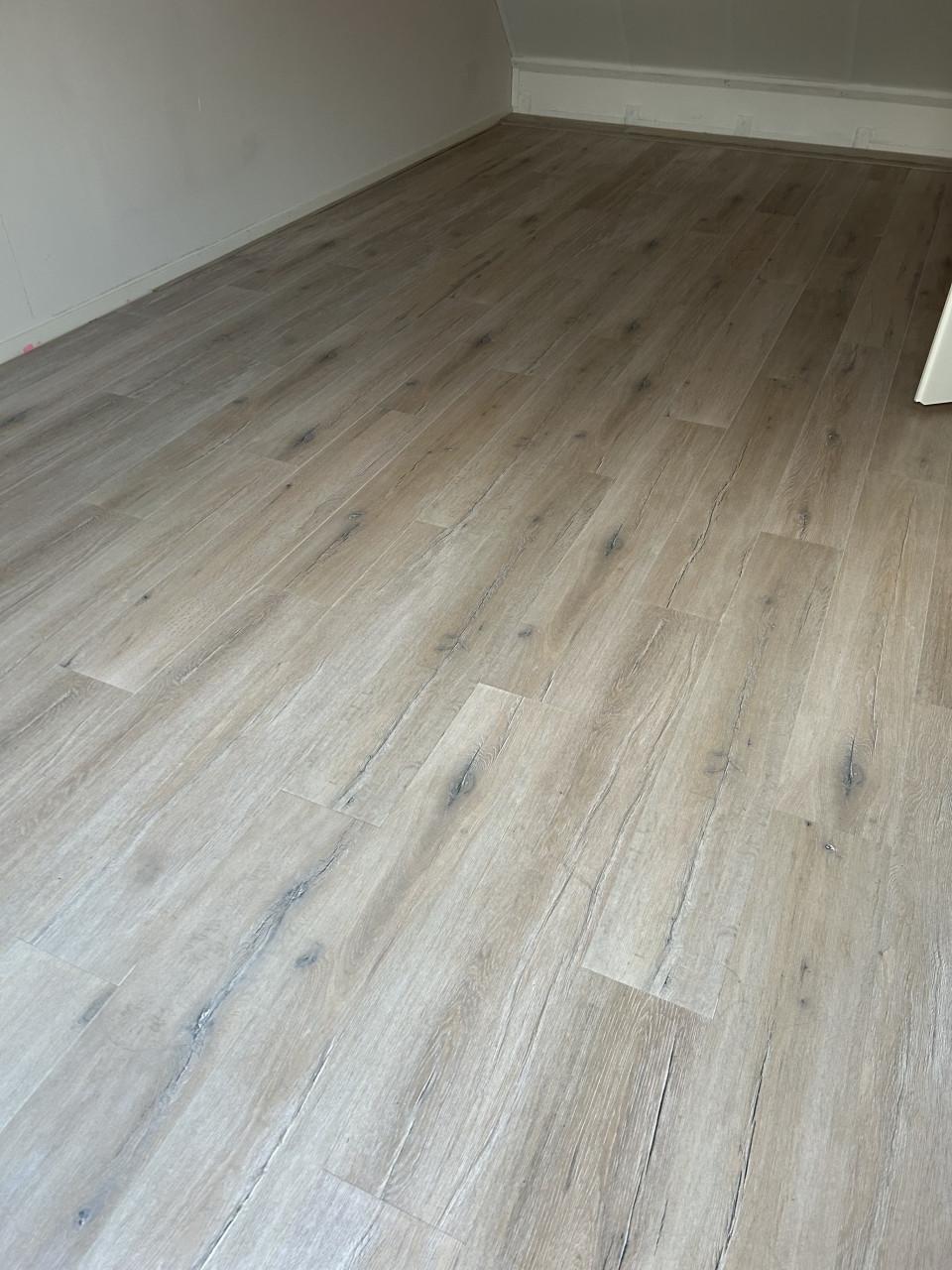 Laminaat licht met grijstinten v groef plinten en ondervloer