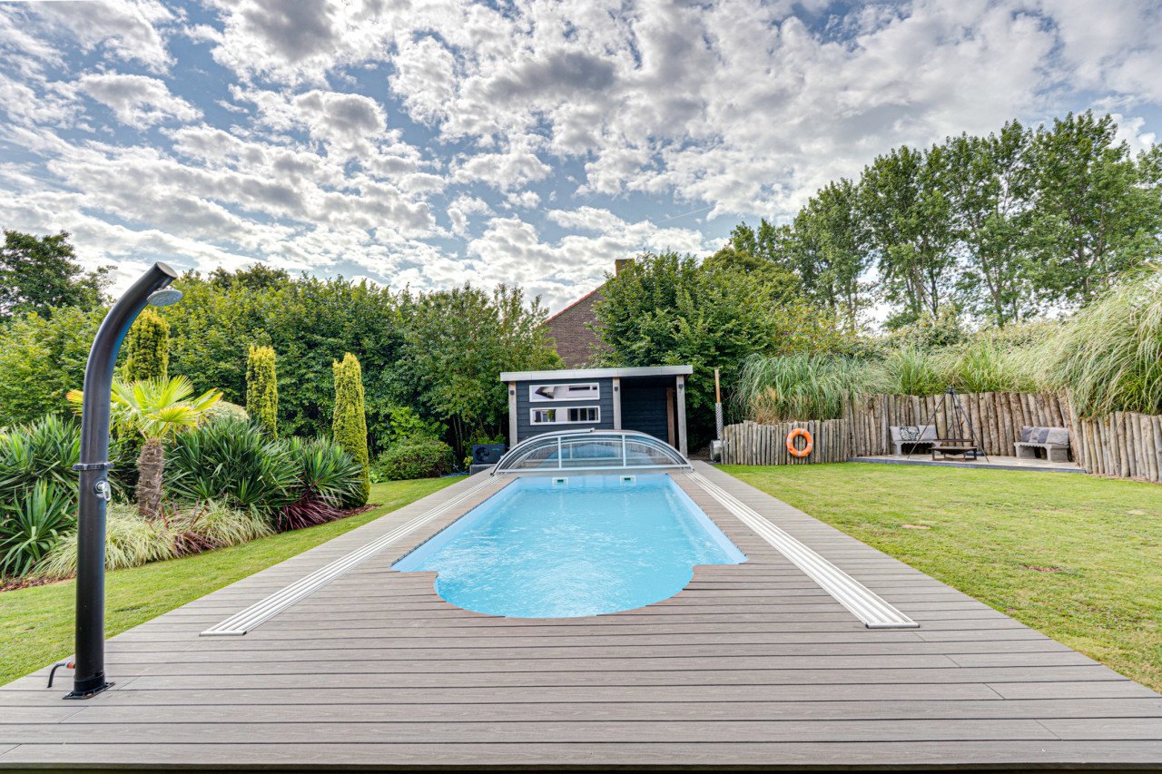 Rietgedekte villa met een overdekt zwembad.