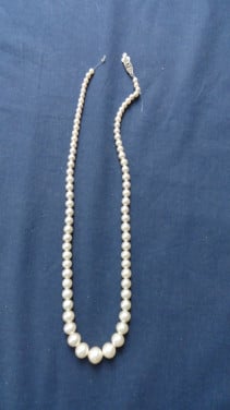 Ketting met van klein naar groot (nep) parels. Met fraai slotje.