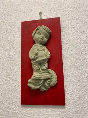 Houten bordje met grijs stenen beeldje erop