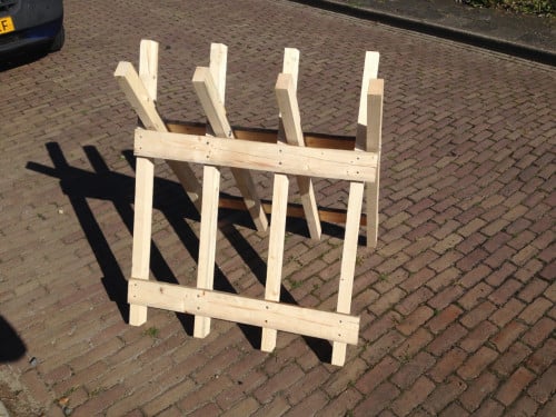 Rechtop hout doorzagen met kettingzaag en robuste zaagbok als werkbank
