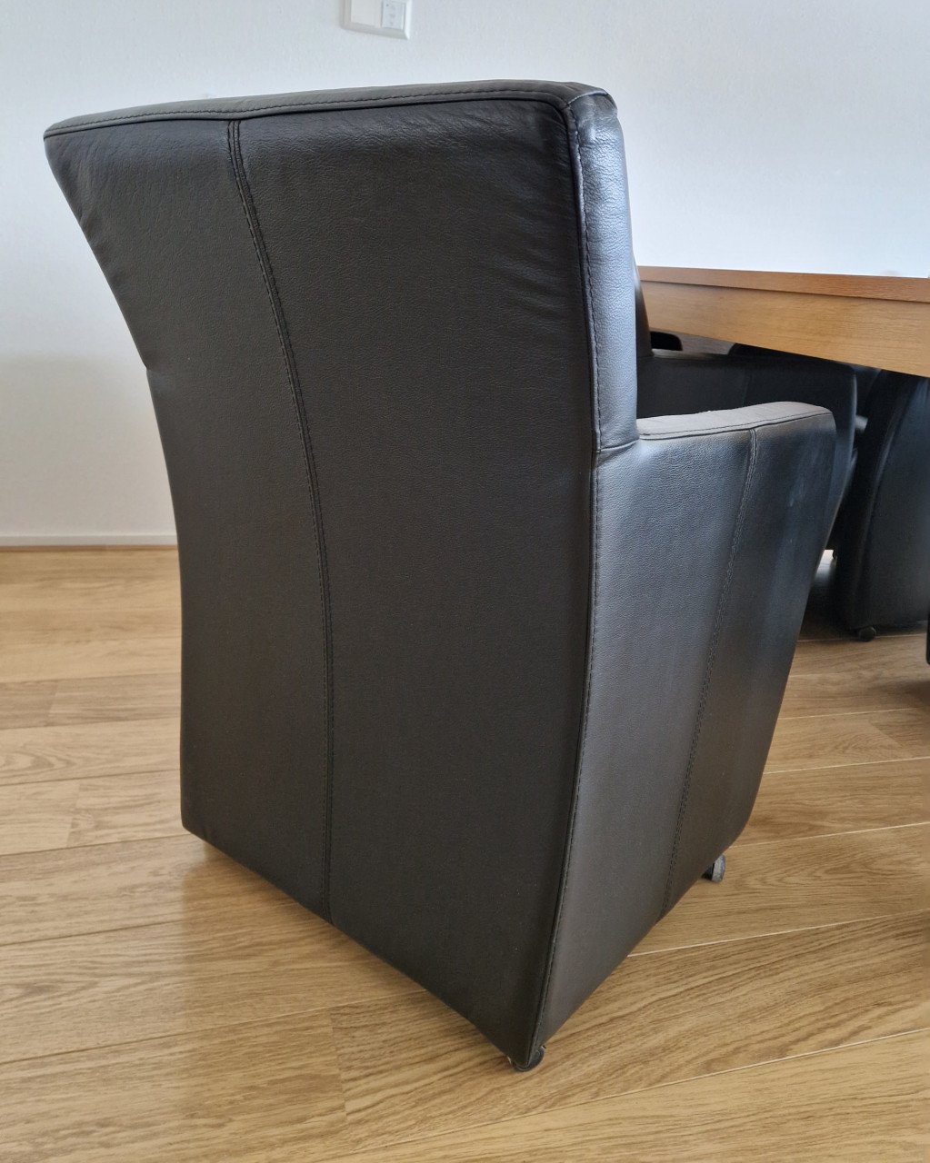 Eethoek met 4 leren stoelen op wieltjes