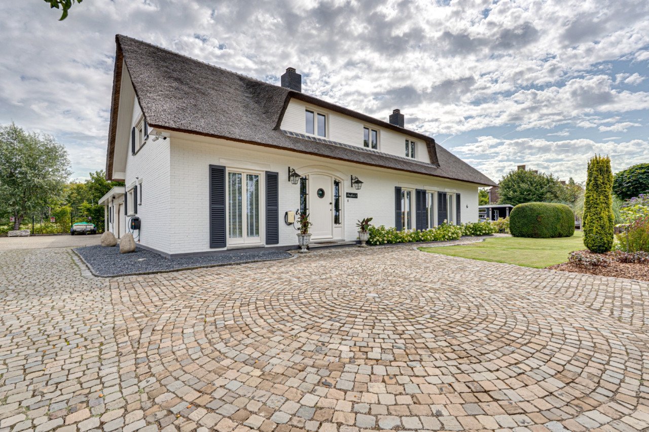 Rietgedekte villa met een overdekt zwembad.