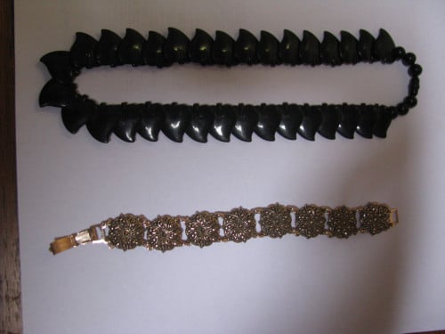 Zwarte ketting, goudkleurige armband.
