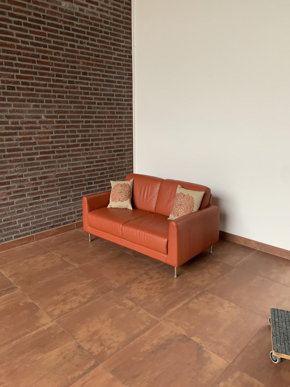 Leuk oranje kleurig bankje met twee kussens