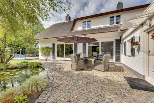 Rietgedekte villa met een overdekt zwembad.