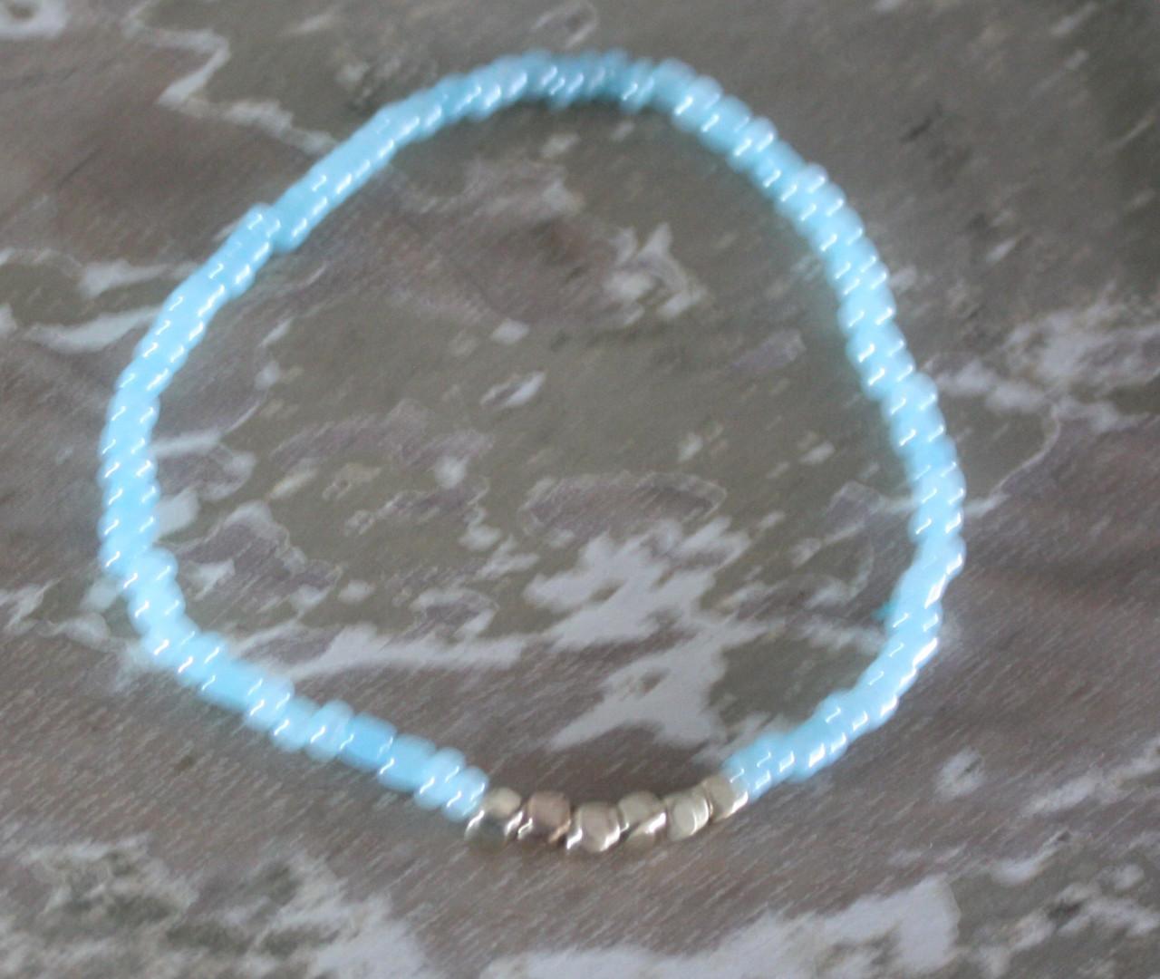 Armbandje rekbaar blauw en goudkleurige kralen