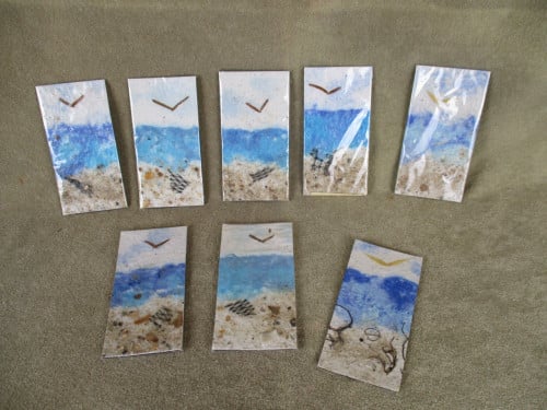7 boekenleggers van handgeschept papier met thema zee en strand.