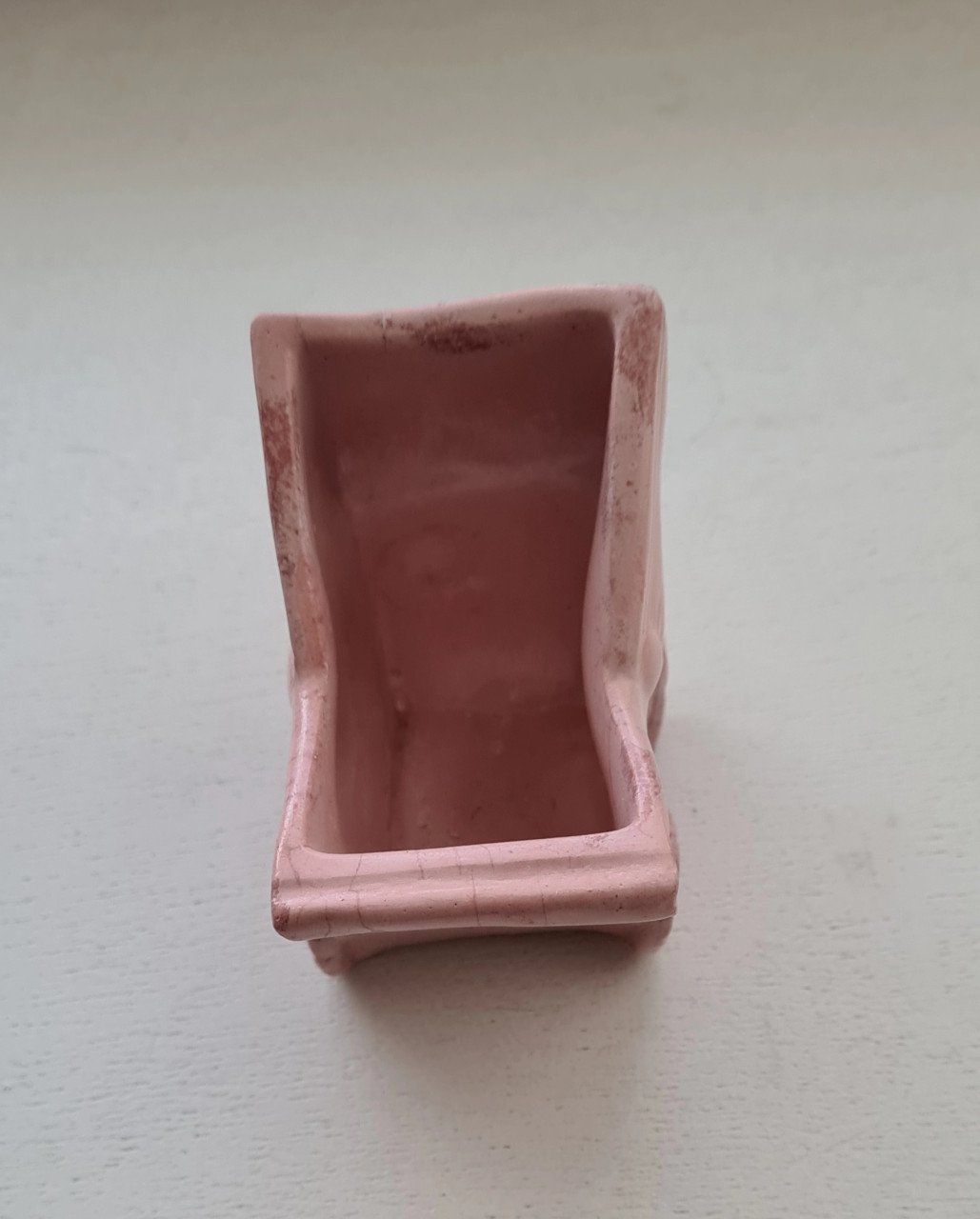 Schattig klein roze bloempotje in de vorm van een kinderwagen