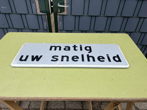 Verkeersbord "matig uw snelheid "