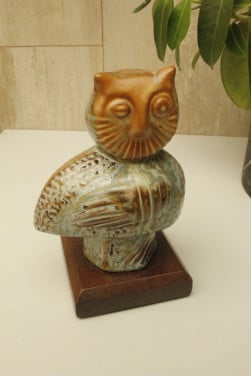 Uiltje op houten voetstuk
