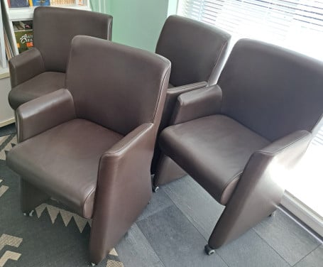 4 bruine kunstlederen stoelen op wieltjes