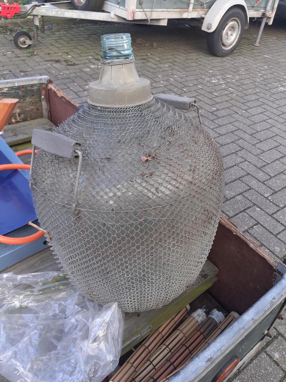 Brocante grote gistfles /wijnfles in ijzeren omhulsel spiraal