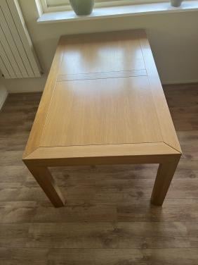 Eiken eettafel met 6 zwarte leren stoelen.