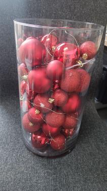 Glazen vaas met rode ballen en verlichting