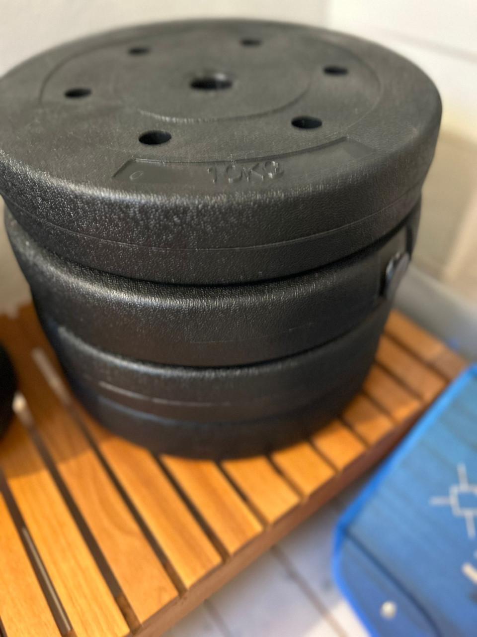 Halterbank met haltergewichten, rubber tegels en magnesium