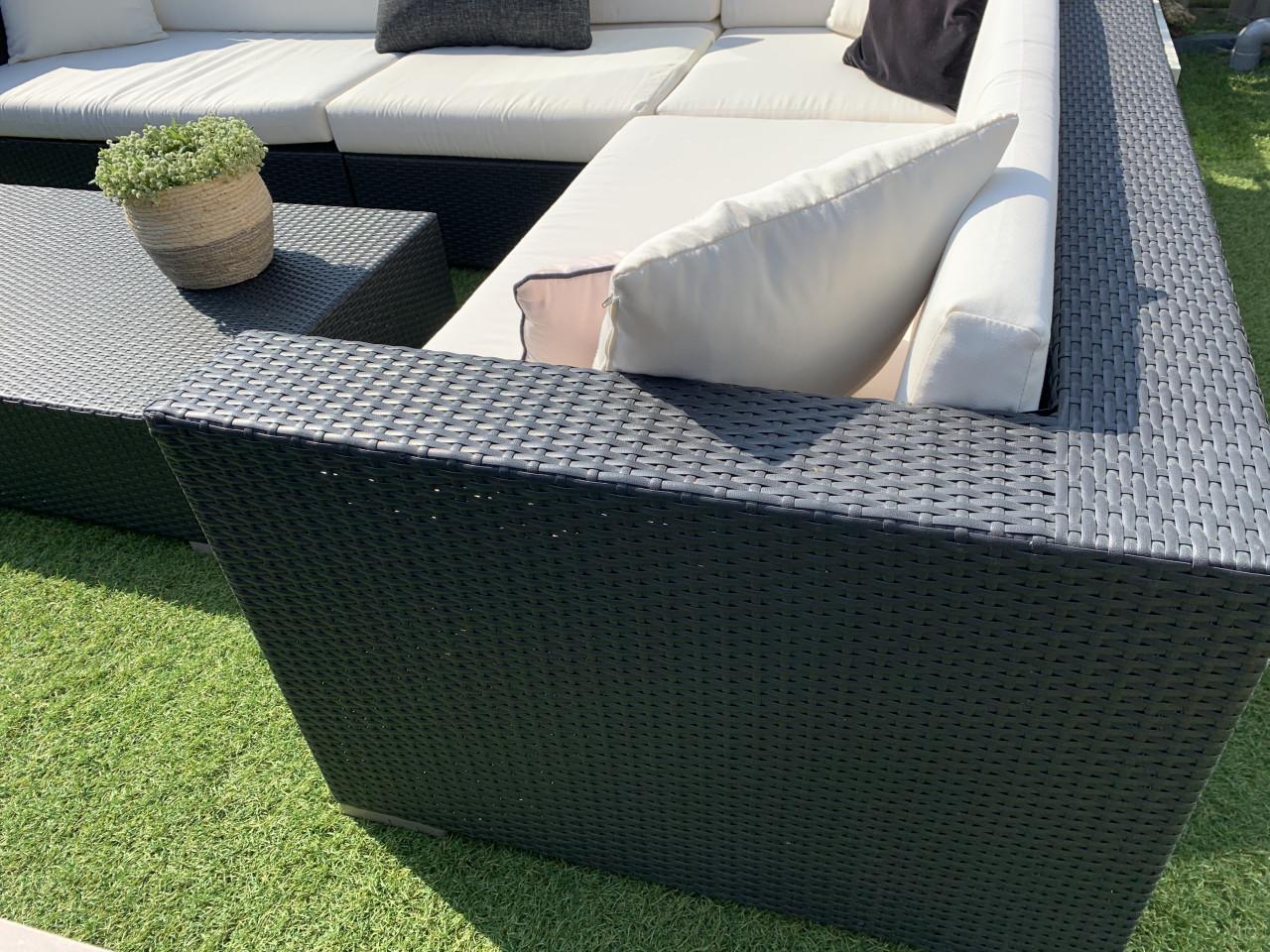 Wicker loungeset zwart met kussens en tafel.