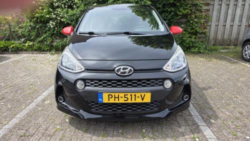 Hyundai I10 2019 met 69300 km Zwart met rode spiegels en sierstrippen.