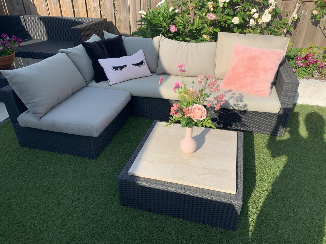 Wicker loungeset met kussens en tafel.