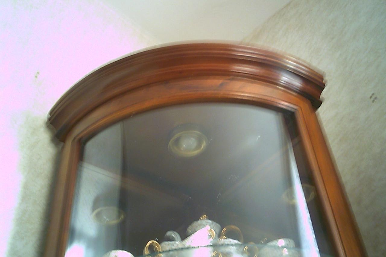 HOEKVITRINE in ronde vorm met spiegelwanden en verlichting.