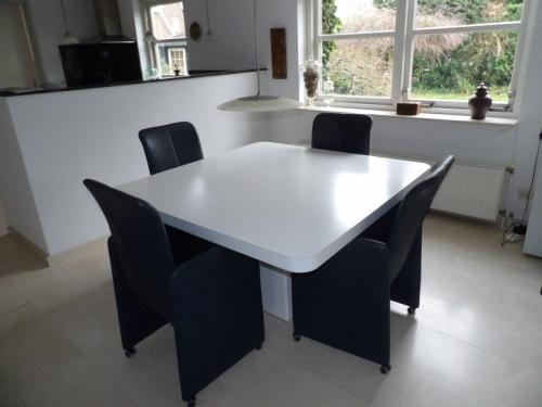 Witte zeer degelijke tafel + 4 verrijdbare leren stoelen