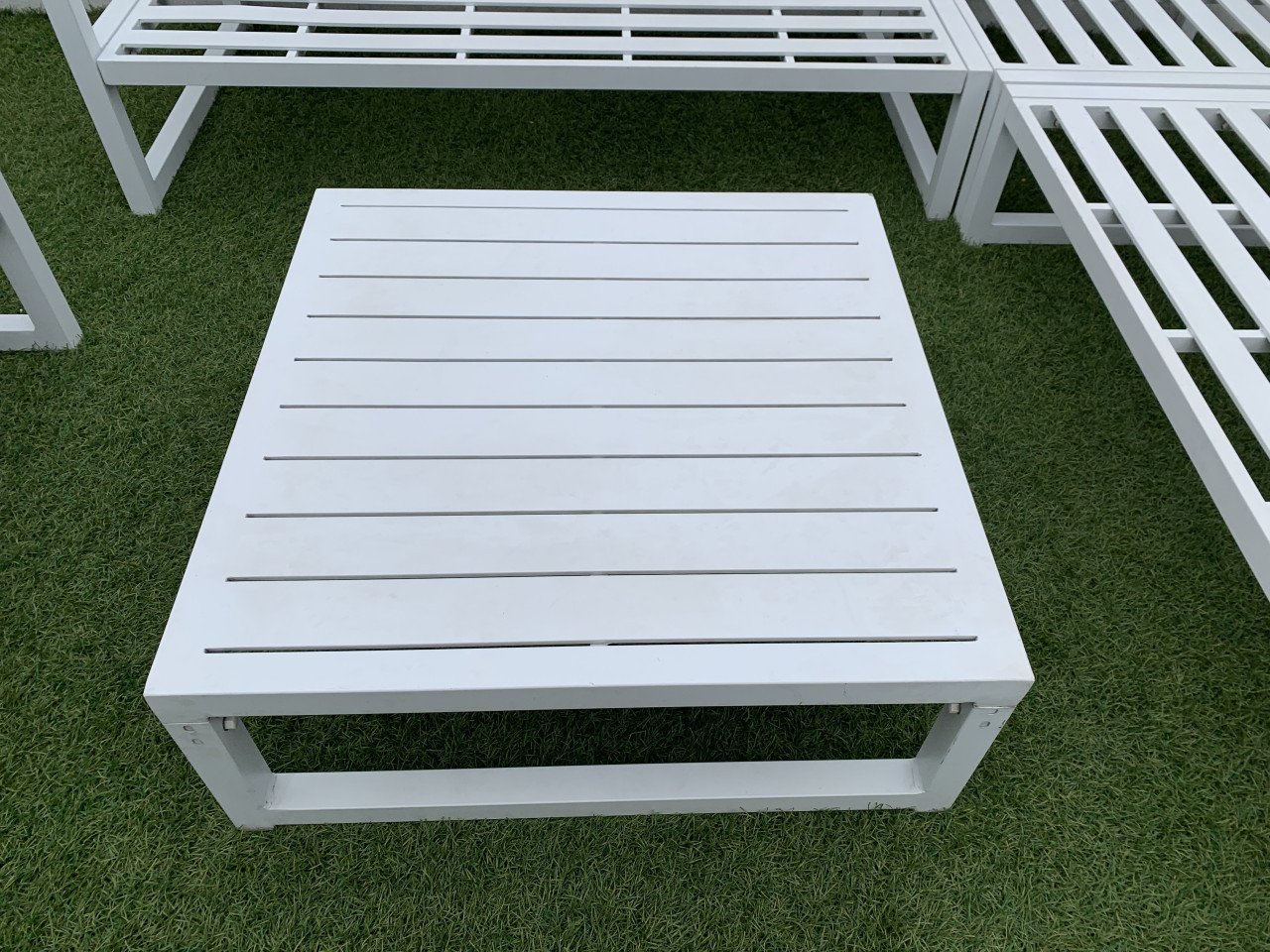 Wit aluminium loungeset met kussens tafel en stoel.
