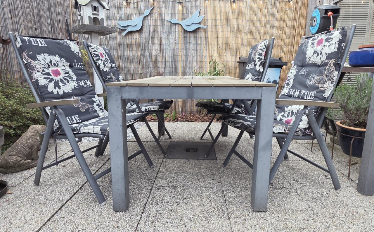 Tuintafel met 4 stoelen en bij passende kussens.