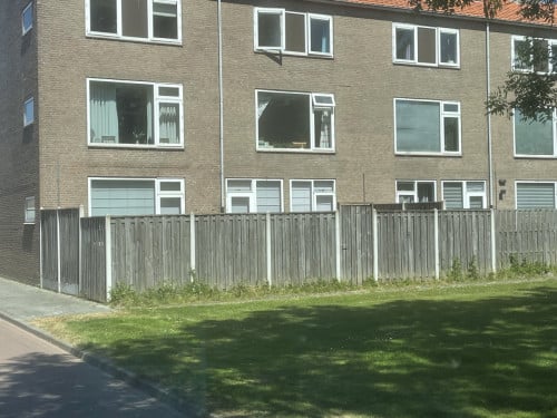Schutting met betonnenpalen en poort