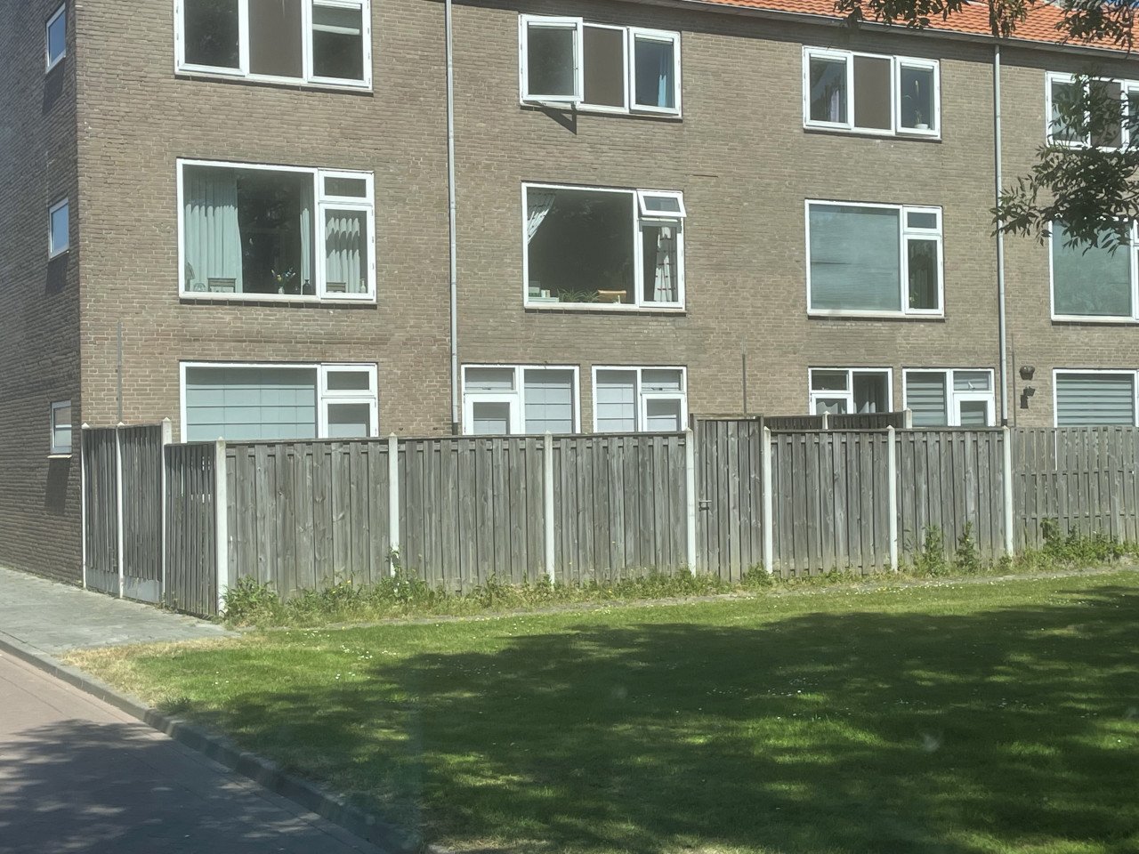 Schutting met betonnenpalen en poort