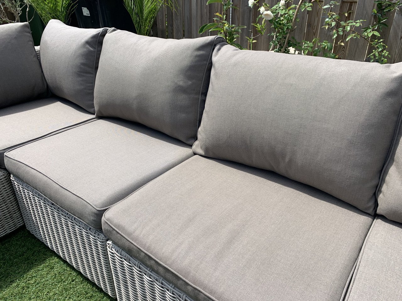 Rieten loungeset met kussens en tafel.