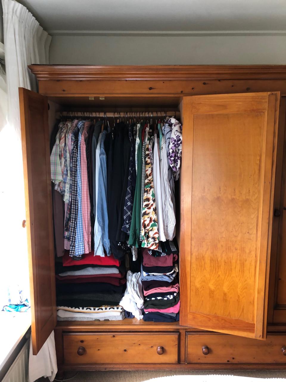 Grote houten kledingkast met deuren en lades.