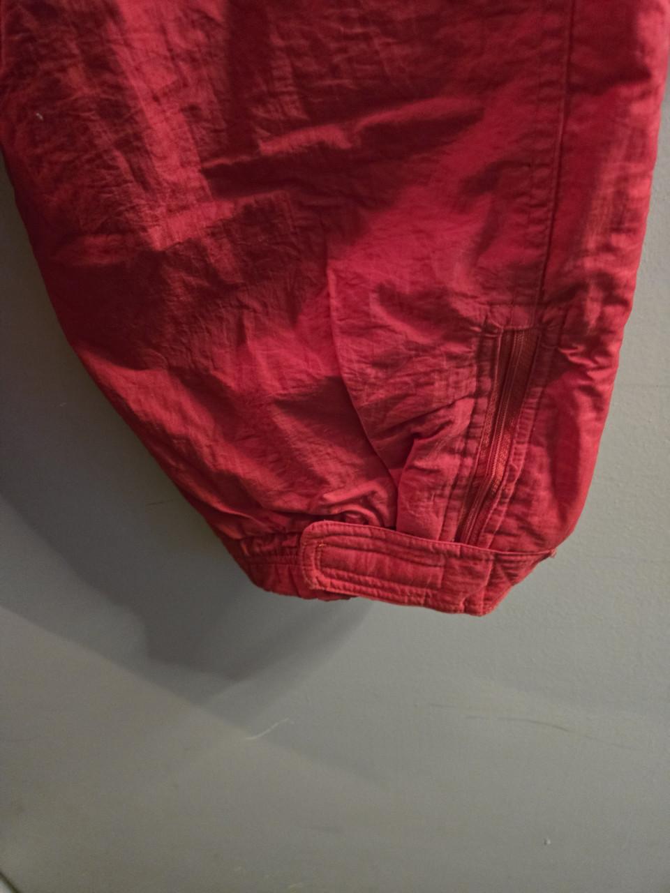 Rode skibroek Maat L  Sluiting met rits en drukker.