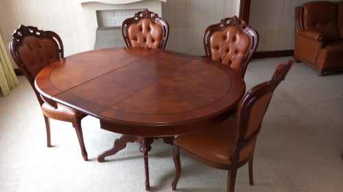 Uitschuifbare tafel met vier bijpassende lederen stoelen