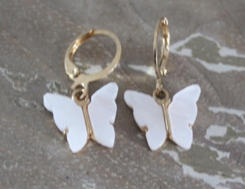 Goud kleurige oorhangers met witte vlinders