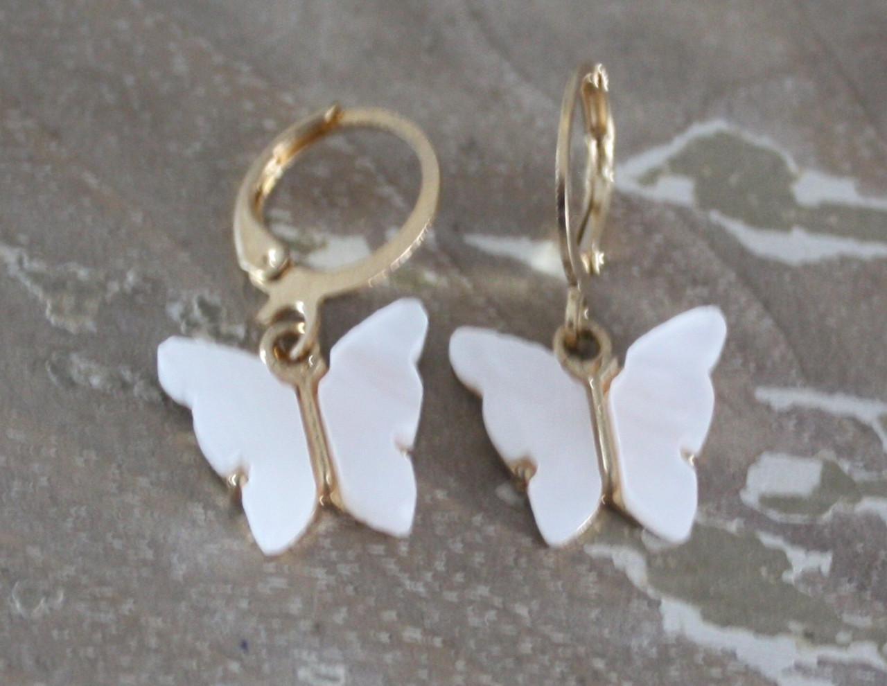 Goud kleurige oorhangers met witte vlinders