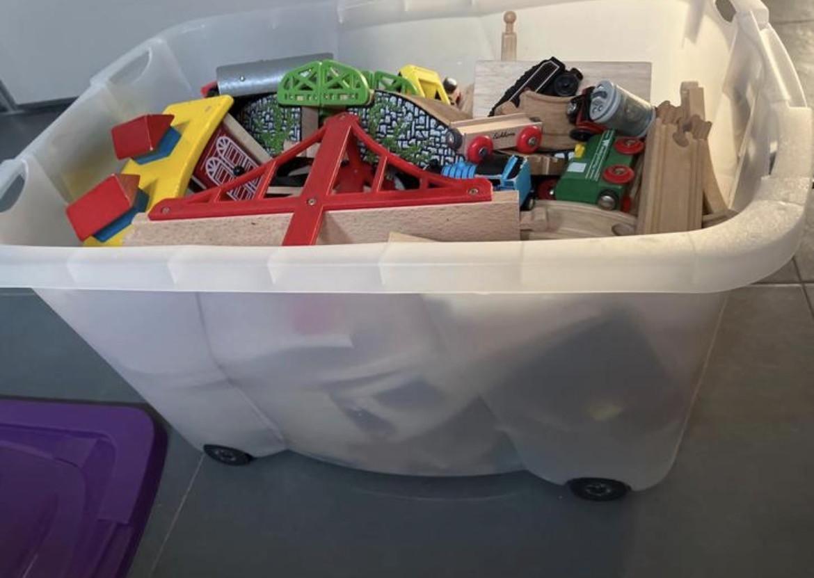 Grote bak met houten treinbaan en treintjes op batterij